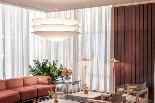 Inneneinrichtung des Saint Hotel in London mit einem großen Sofa, Tischen, Stühlen und Pflanzen.