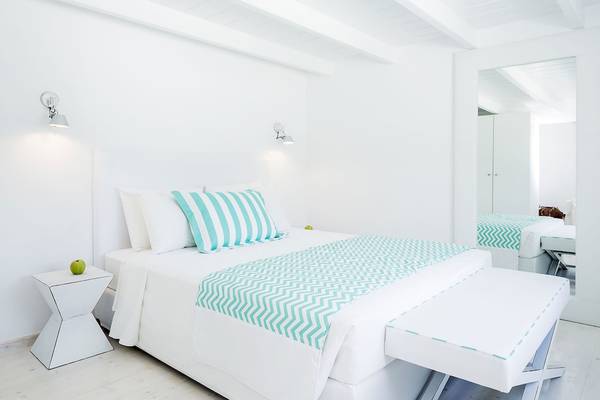 Weißes Schlafzimmer im Archipelagos Hotel mit Bett, Kissen und Nachttisch