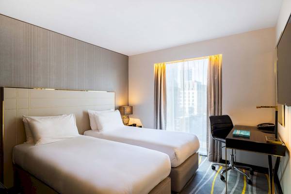 Doppelzimmer im Saint Hotel London mit zwei Betten, Schreibtisch und Stadtblick.