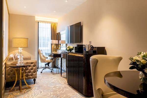 Innenansicht der Suite im Saint Hotel in London mit Wohnzimmer, Schreibtisch und Fernseher.