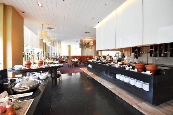 Innenansicht des Restaurants im Century Park Hotel mit Buffet und Tischen.