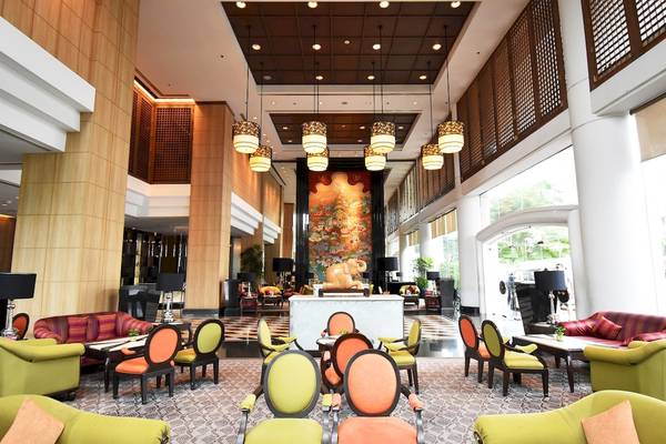 Lobby des Century Park Hotels mit bunten Stühlen und Tischen, Wanddekoration und Lampen.