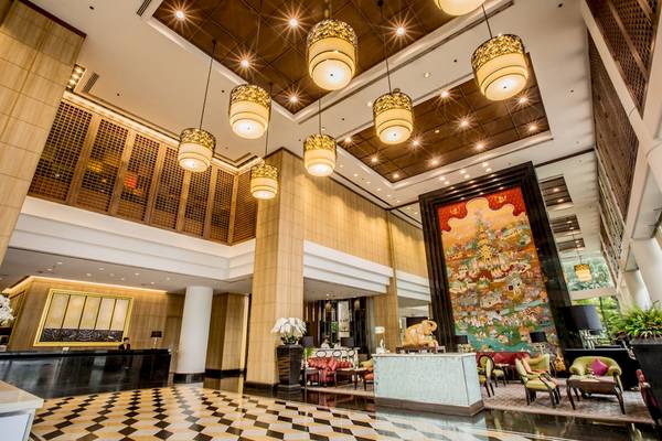 Lobby des Century Park Hotels mit schwarzen und weißen Fliesenboden und Holzsäulen.