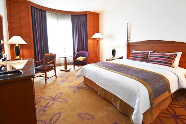 Hotelzimmer im Century Park Hotel mit Doppelbett, Sesseln, Schreibtisch und Lampen.