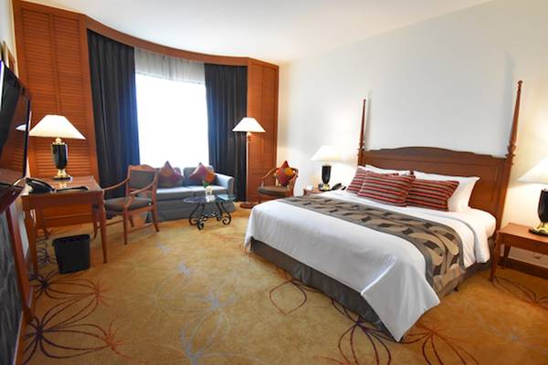 Hotelzimmer im Century Park Hotel mit Bett, Sofa, Schreibtisch und Lampen.