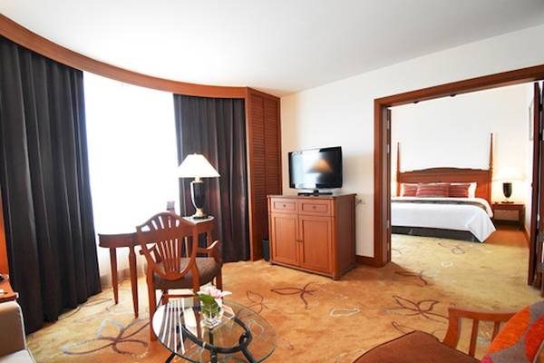 Innenansicht eines Zimmers im Century Park Hotel mit Wohnzimmer, Schreibtisch und Schlafzimmer.