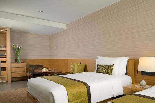 Doppelzimmer im JC Kevin Sathorn Bangkok Hotel mit zwei Betten, Dekor und Möbeln.