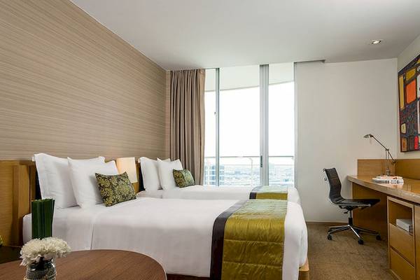Doppelbettzimmer im JC Kevin Sathorn Bangkok Hotel mit Stadtblick und moderner Einrichtung.