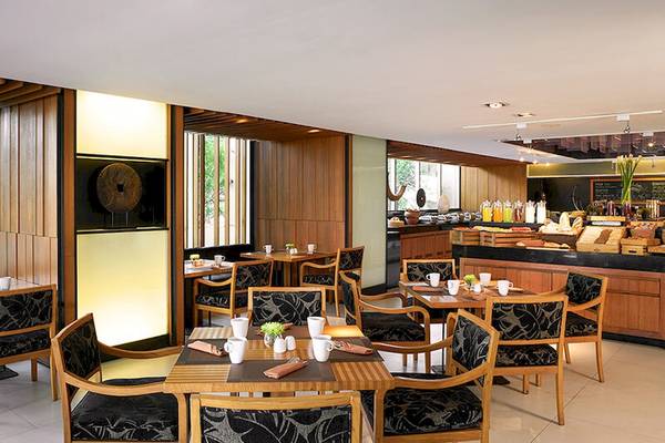 Frühstücksraum im JC Kevin Sathorn Bangkok Hotel mit Holzmöbeln und Buffet.