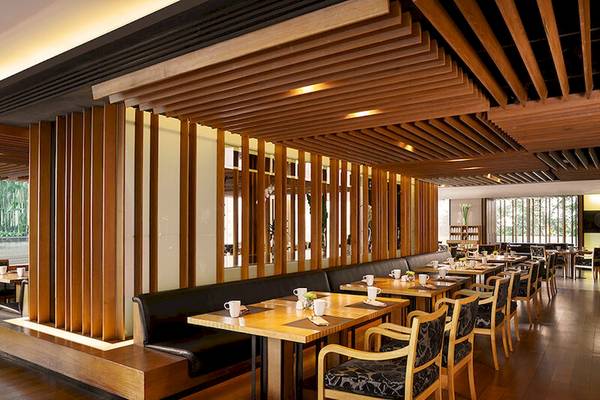 Innenansicht des JC Kevin Sathorn Bangkok Restaurants mit hölzerner Decke und Möbeln.