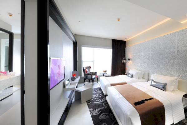 Innenansicht eines Schlafzimmers im Mode Sathorn Hotel mit zwei Betten, Fernseher und Waschtisch.