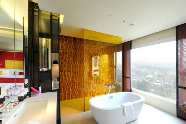 Badezimmer des Mode Sathorn Hotels mit Badewanne, Dusche und Stadtblick.