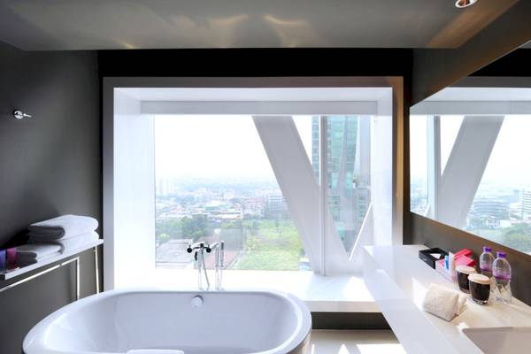 Badezimmer im Mode Sathorn Hotel mit Badewanne, Fenster und Stadtblick