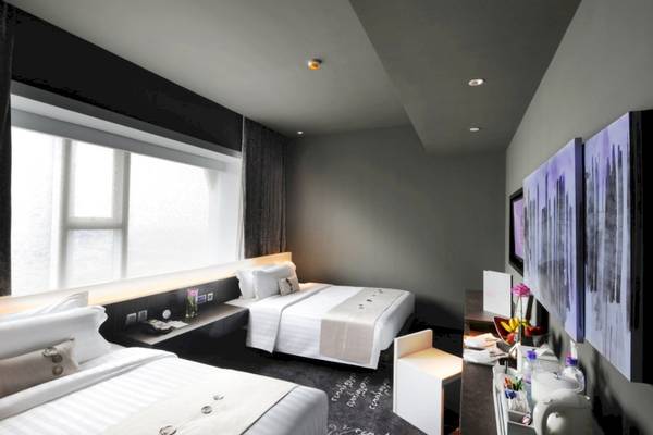 Ein modernes Hotelzimmer im Mode Sathorn mit zwei Betten, einem Schreibtisch und einer Aussicht aus dem Fenster.