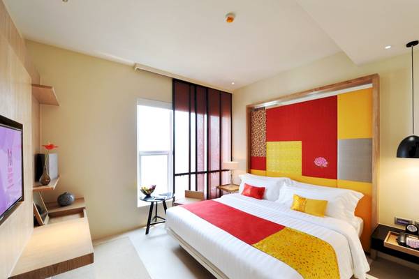 Das Schlafzimmer im Mode Sathorn Hotel mit buntem Wanddesign, bequemem Bett und Flachbildfernseher.