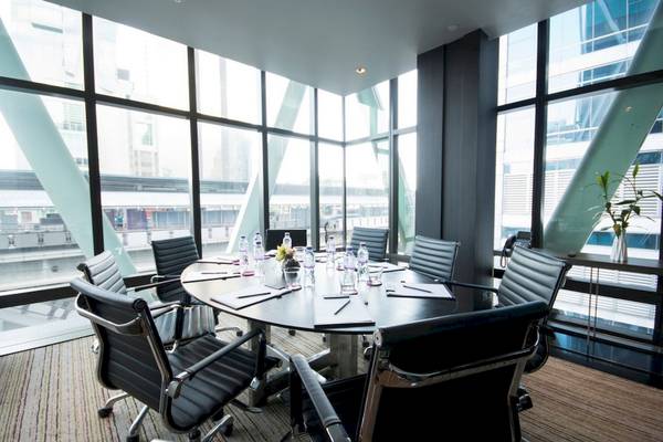 Konferenzraum im Mode Sathorn Hotel mit ovalem Tisch, schwarzen Lederstühlen und großen Fenstern.