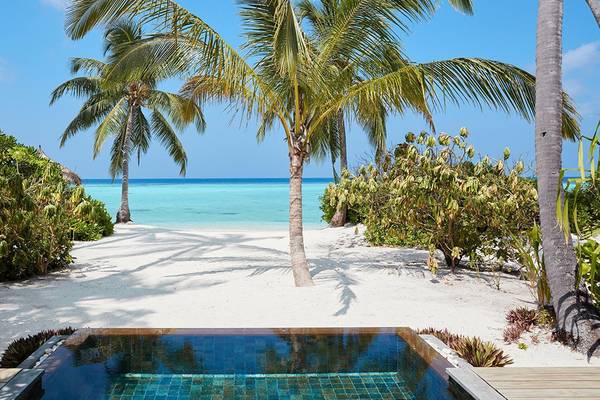 Privatpool am Strand des Amari Havodda Maldives mit Palmen und Meer im Hintergrund