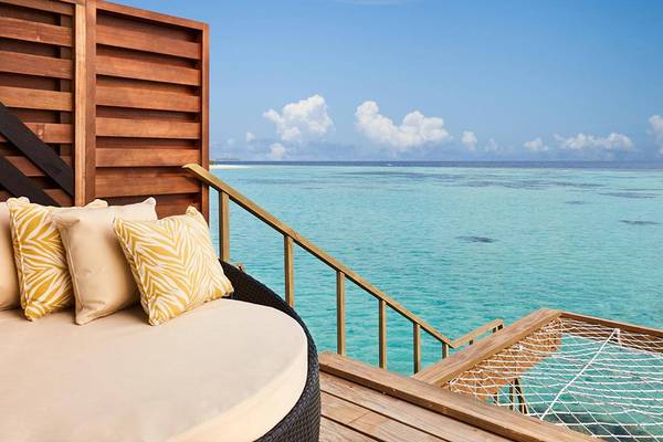 Terrasse des Amari Havodda Maldives mit Sofa und Hängematte mit Blick auf das Meer