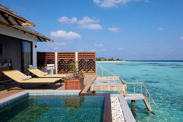 Außenpool mit Liegen und Meerblick im Amari Havodda Maldives Hotel.