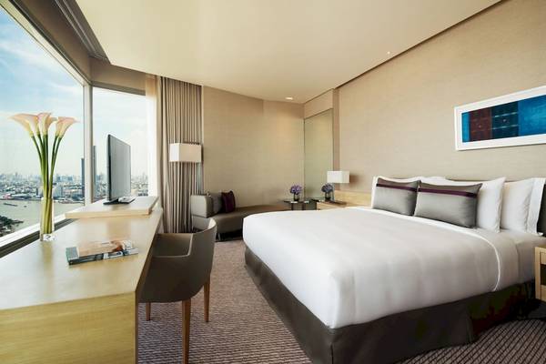 Hotelzimmer im AVANI+ Riverside Bangkok mit Blick auf die Stadt.