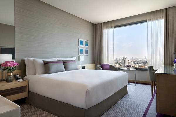 Hotelzimmer im AVANI+ Riverside Bangkok mit Stadtblick, modernem Design und bequemem Bett.