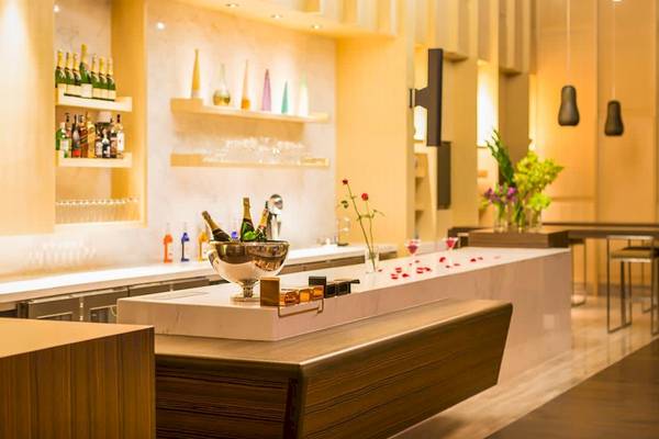 Bar im AVANI+ Riverside Bangkok Hotel mit Flaschen, Cocktails und Dekor
