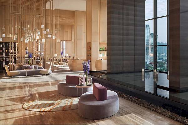 Lobby des AVANI+ Riverside Bangkok Hotels mit modernen Möbeln und Blick auf die Stadt.