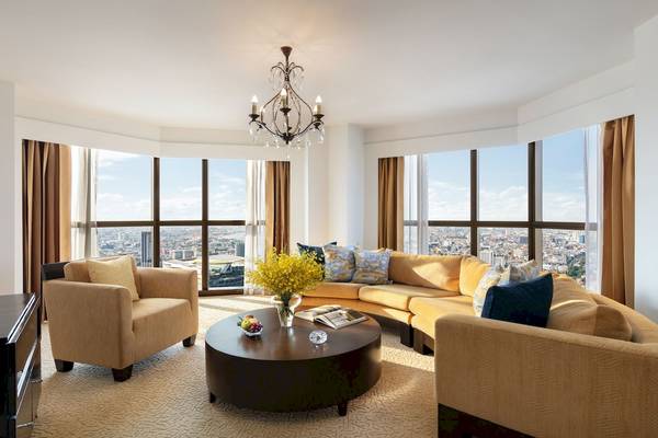 Wohnzimmer im Tower Club at Lebua mit Sofas, Tisch, Vorhängen und Fenstern.