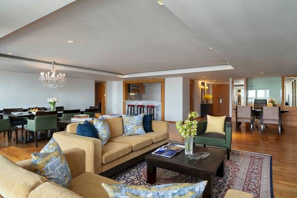 Wohnzimmer im Tower Club At Lebua Hotel mit Couch, Tisch, Stühlen und Esstisch.