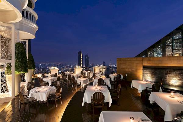 Terrassenrestaurant des Tower Club At Lebua mit Blick auf die Stadt bei Nacht.