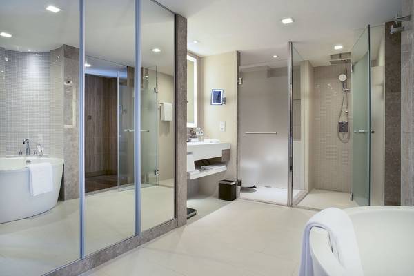 Badezimmer im Novotel Bangkok Sukhumvit 20 mit Badewanne, Glasdusche und Waschbecken.