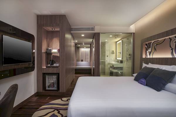 Hotelzimmer im Novotel Bangkok Sukhumvit 20 mit Fernseher, Minibar und Badezimmer.