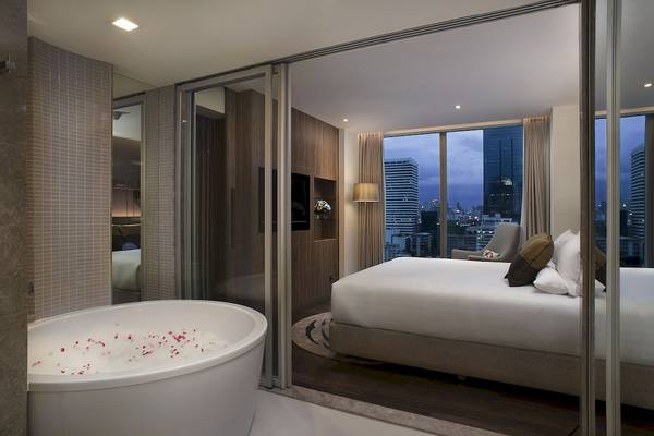 Schlafzimmer des Novotel Bangkok Sukhumvit 20 mit Badewanne und Stadtaussicht