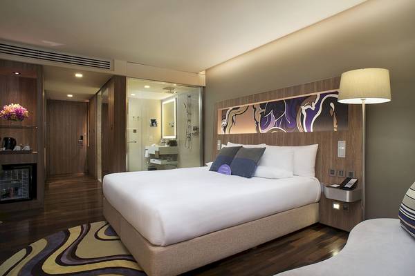 Hotelzimmer im Novotel Bangkok Sukhumvit 20 mit Bett, Lampen und Badezimmer.