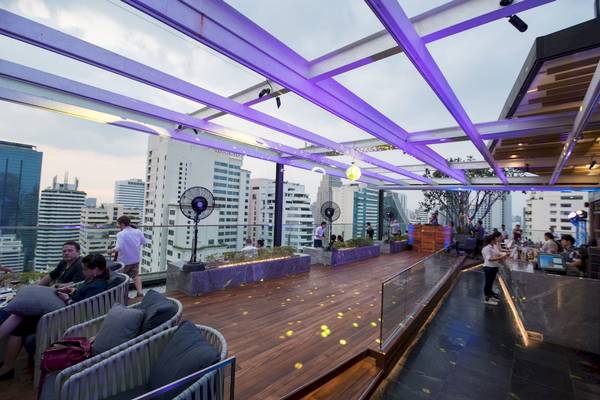 Hotelterrasse des Novotel Bangkok Sukhumvit 20 mit Blick auf die Stadt und farbige Beleuchtung.