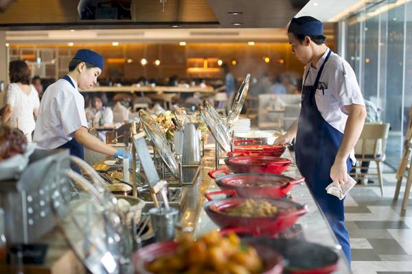 Buffet-Servicemitarbeiter im Novotel Bangkok Sukhumvit 20 bereiten Speisen zu.