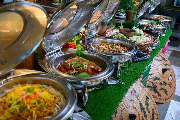 Buffet-Tisch im Novotel Bangkok Sukhumvit 20 mit verschiedenen Gerichten in Edelstahlschüsseln.
