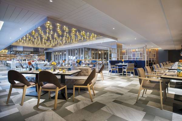 Innenansicht des Restaurants im Novotel Bangkok Sukhumvit 20 mit geometrischem Bodenmuster und moderner Einrichtung.