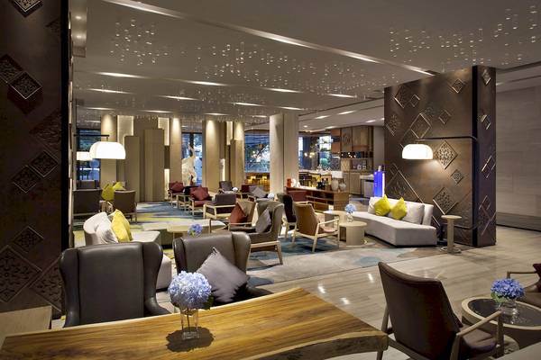 Hotellobby des Novotel Bangkok Sukhumvit 20 mit modernen Möbeln und geometrischen Mustern.