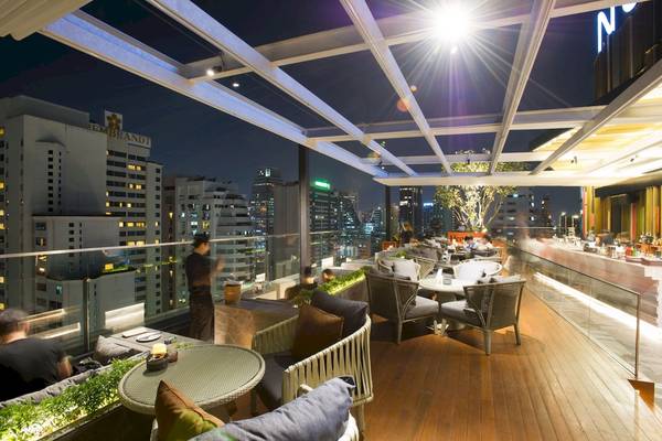 Abendliche Lounge auf dem Dach des Novotel Bangkok Sukhumvit 20 mit Blick auf die Stadt.