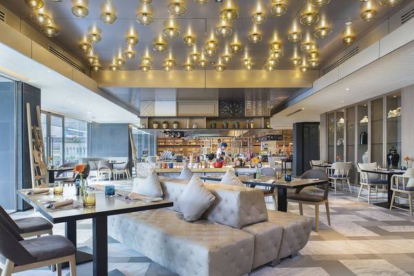 Innenbereich des Novotel Bangkok Sukhumvit 20 mit gepolsterten Sofas und Tischen, beleuchteten Decken und Einrichtungsgegenständen.