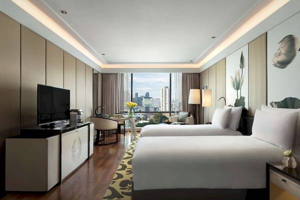 Suite-Zimmer im Siam Kempinski Hotel Bangkok mit zwei Betten, Stadtblick und modernen Annehmlichkeiten.
