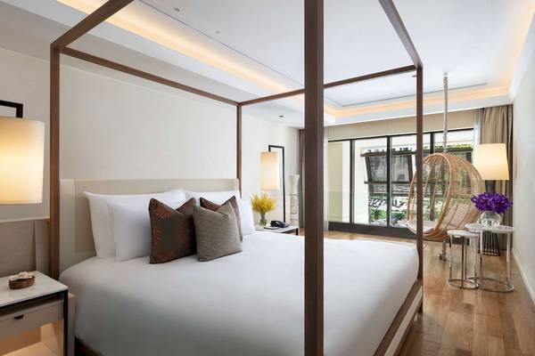 Schlafzimmer im Siam Kempinski Hotel Bangkok mit einem großen Bett und Fenstern.