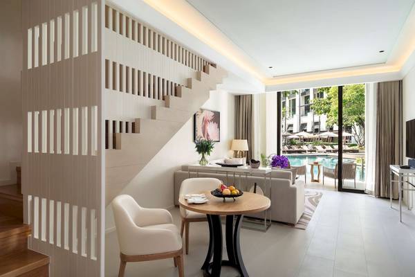 Modernes Wohnbereich im Siam Kempinski Hotel Bangkok mit Swimmingpool im Hintergrund.