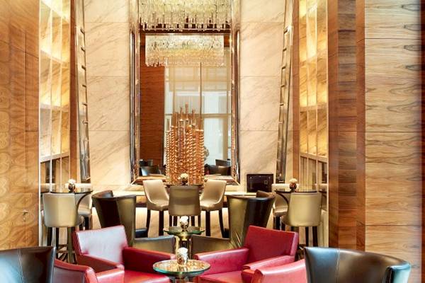 Lobbybereich des Siam Kempinski Hotels in Bangkok mit Holzwänden und Möbeln.