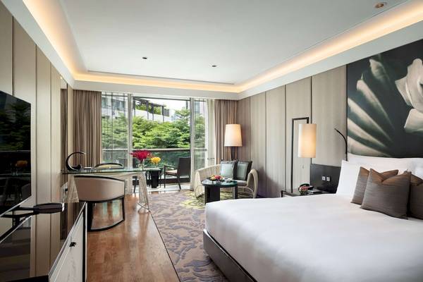 Innenansicht des Schlafzimmers im Siam Kempinski Hotel Bangkok mit Blick auf eine Terrasse.