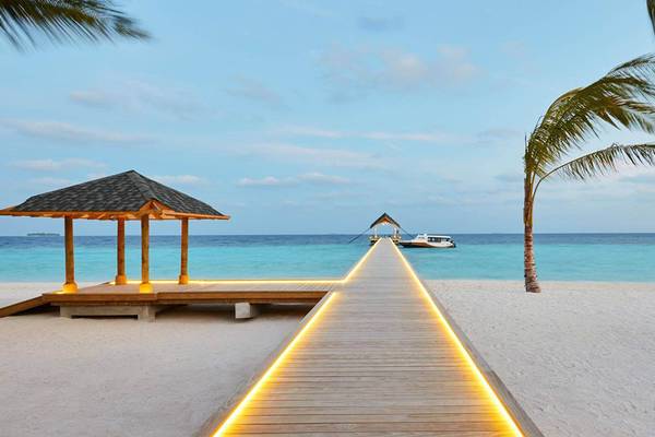 Beleuchteter Holzsteg zum Amari Havodda Hotel im Malediven