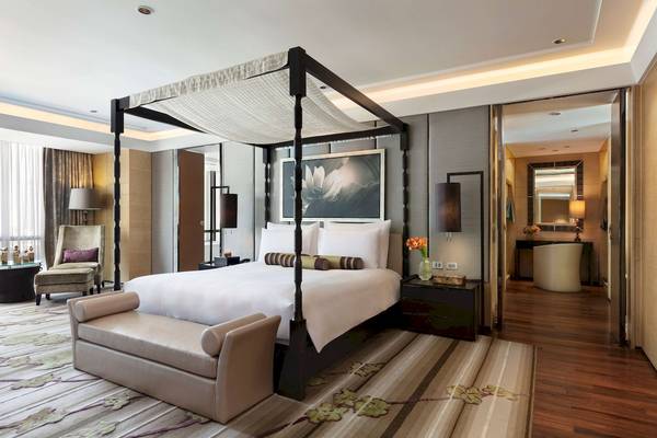 Schlafzimmer im Siam Kempinski Hotel Bangkok mit Himmelbett, Dekor und Möbeln.
