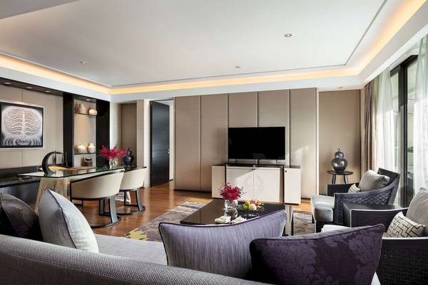 Wohnzimmer im Siam Kempinski Hotel Bangkok mit moderner Einrichtung und Blick auf die Stadt.