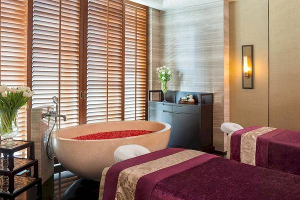 Spa-Bereich im Siam Kempinski Hotel Bangkok mit Badewanne und zwei Massageliegen.